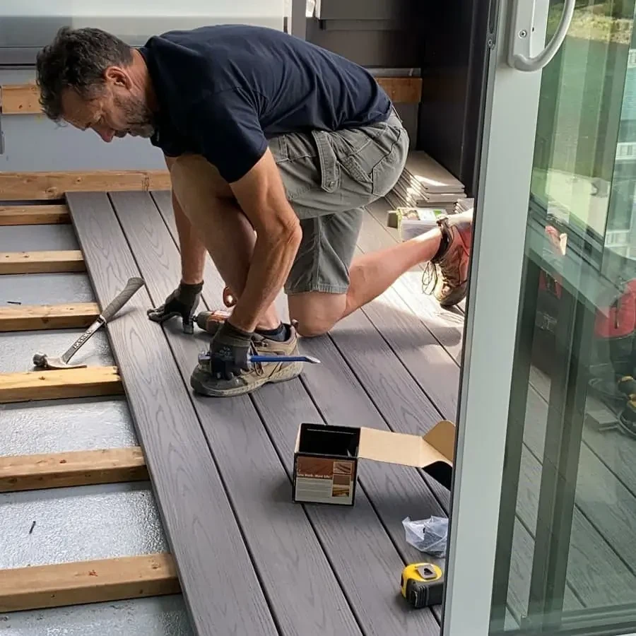 Wes installing composite deck boards — hands-on craftsmanship