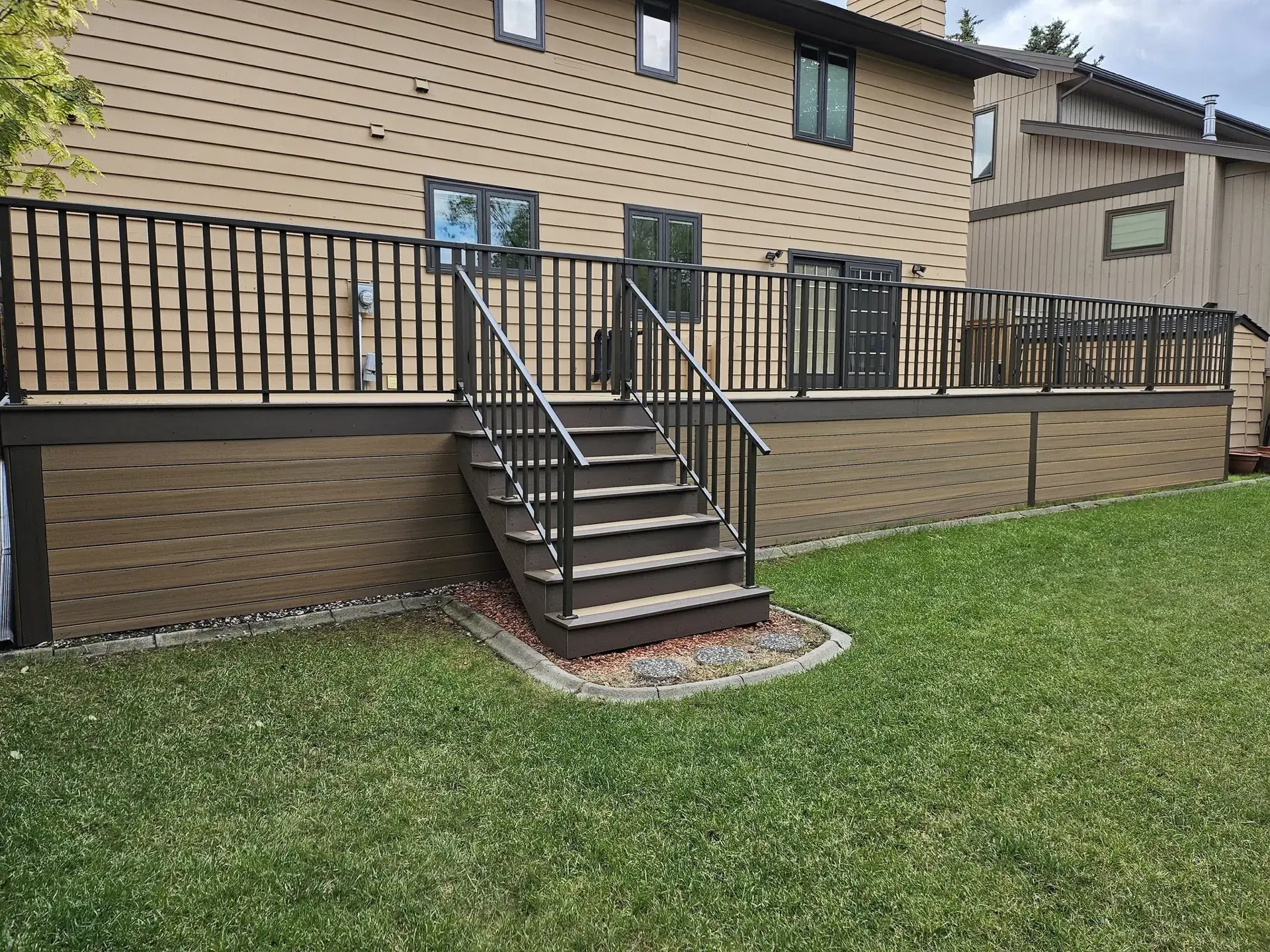 Elevated balcony deck with black metal railing — Calgary