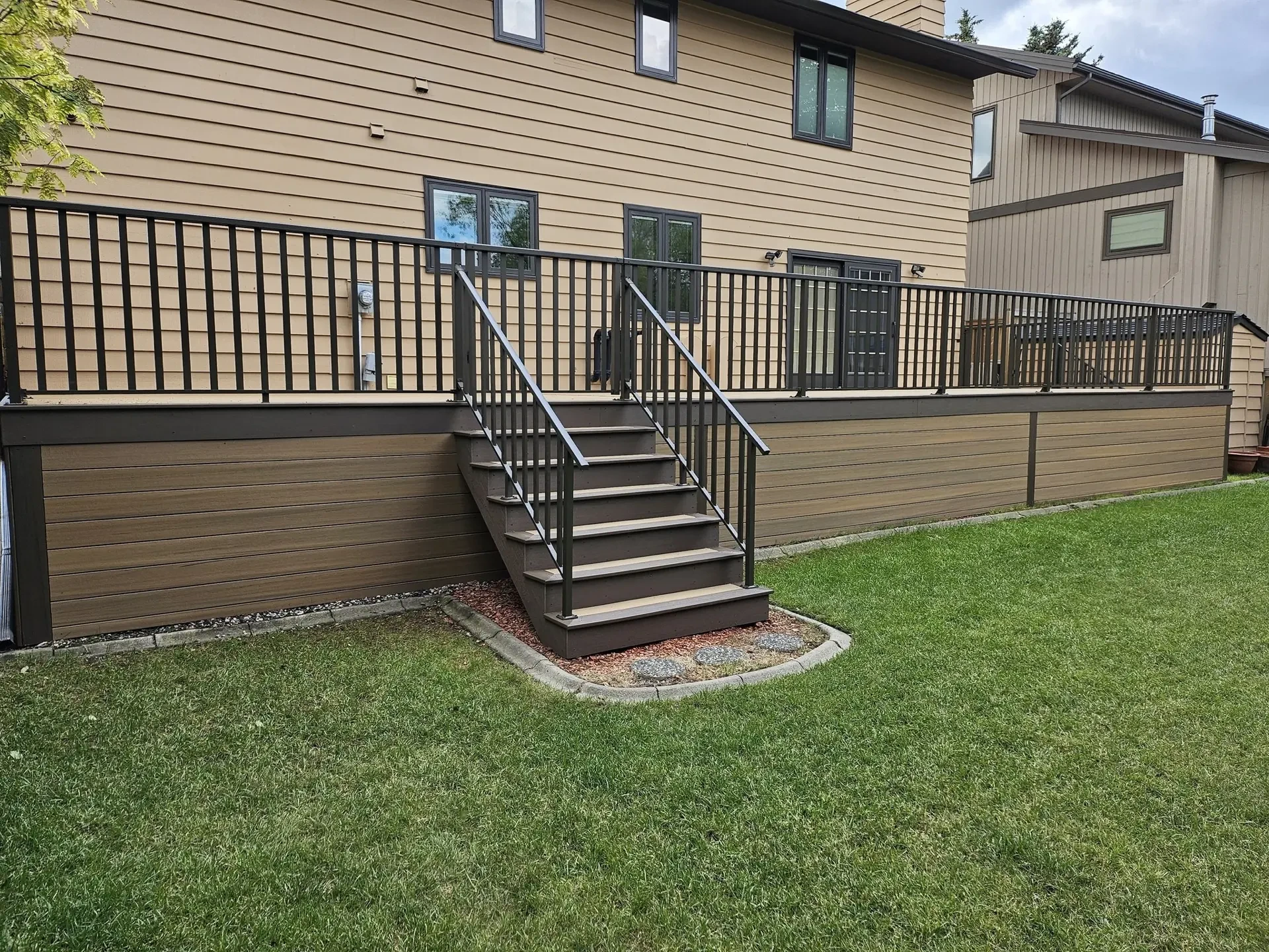 Elevated balcony deck with black metal railing — Calgary