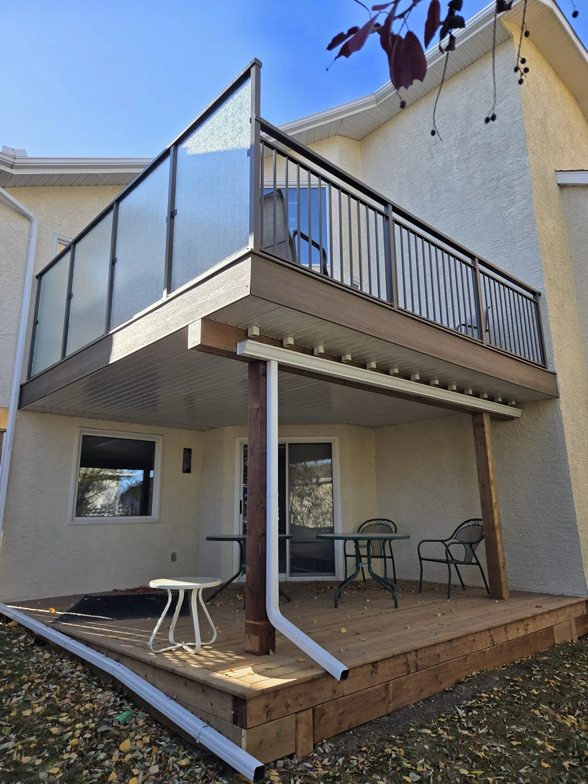 Composite deck railing installed against stucco house in Calgary