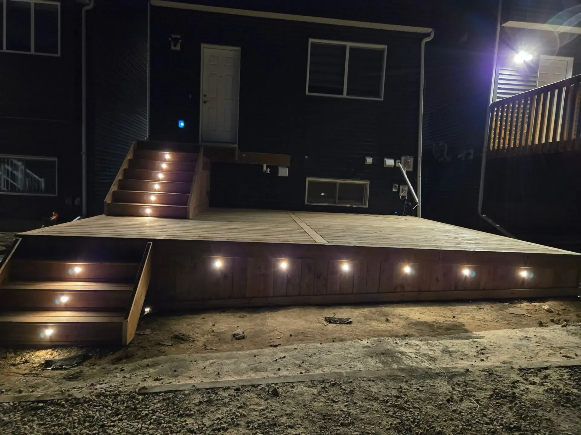 Deck with LED Stair Lights — Night View — Calgary composite deck by Serenity Construction