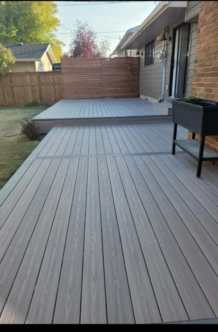 Multi-level grey composite deck with privacy screen — Calgary