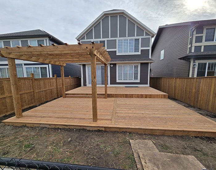 Wooden deck with pergola attached to a modern home, showcasing custom outdoor living space in Calgary.