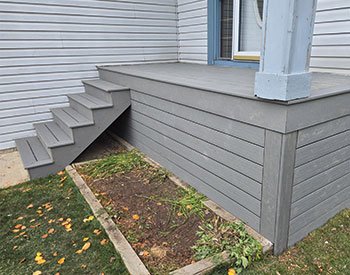 Custom gray deck with stairs, showcasing Serenity Construction Ltd.'s craftsmanship for outdoor living spaces in Calgary.