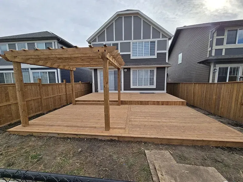 Contractor discussing pool deck installation options with a homeowner in a backyard